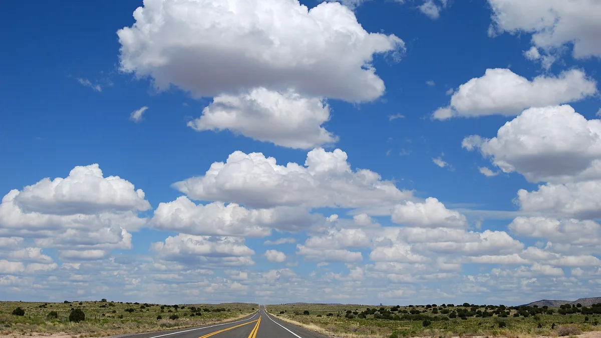 A straight Route 66 road in Arizona beneath a broad sky